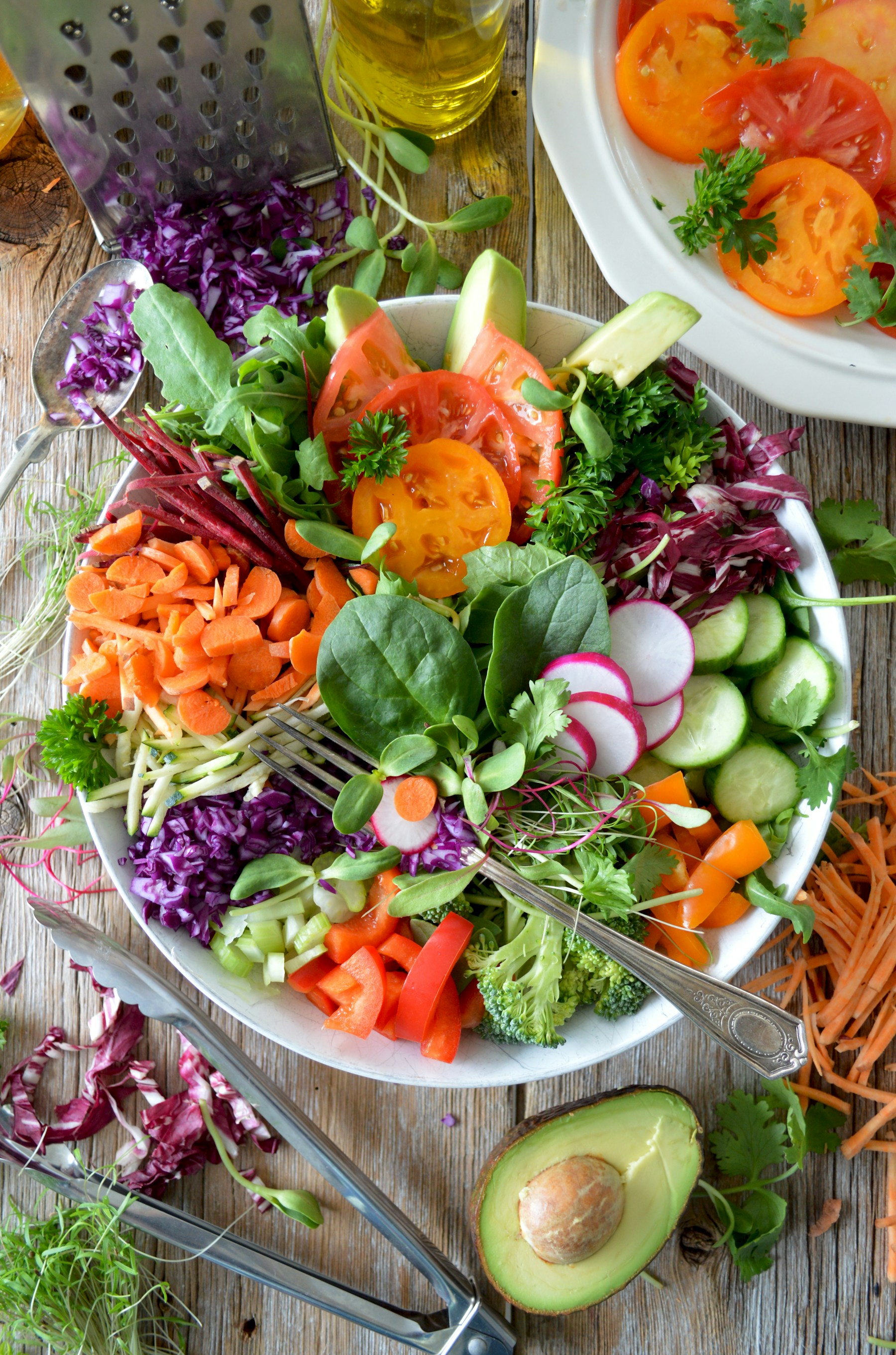 A fresh bowl of leafy greens, tomatoes and vegetables on a kitchen table